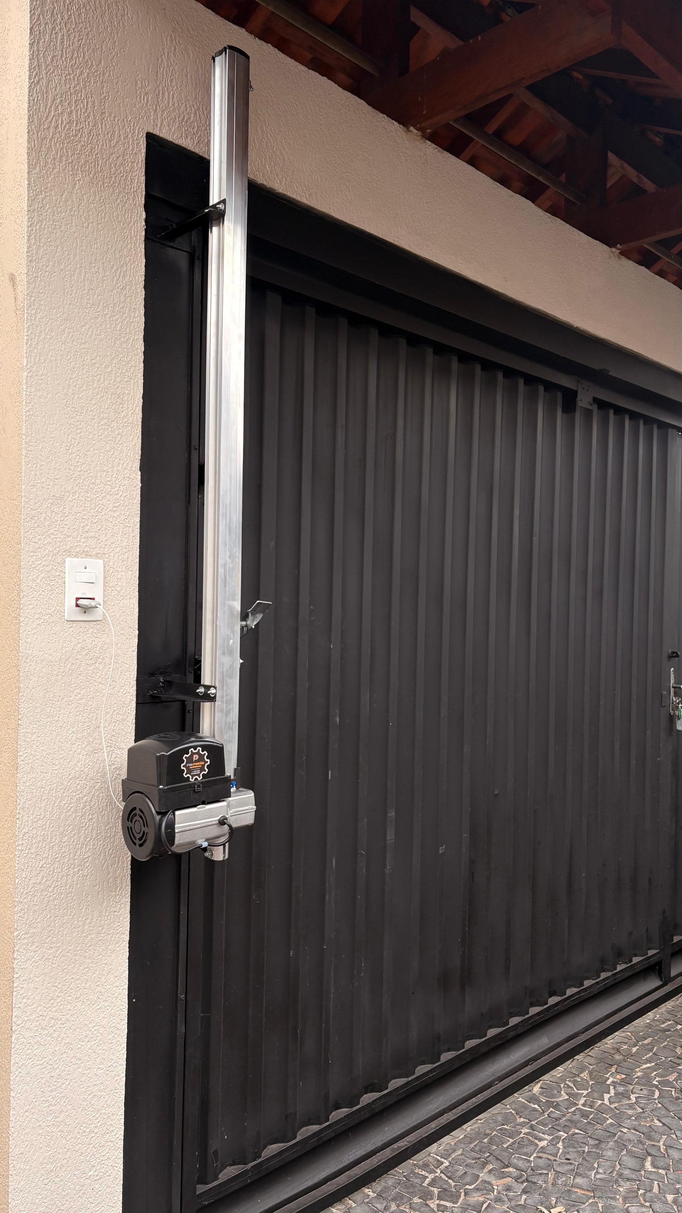 Técnico da Pira Portões instalando automação em portão basculante — imagem 3
